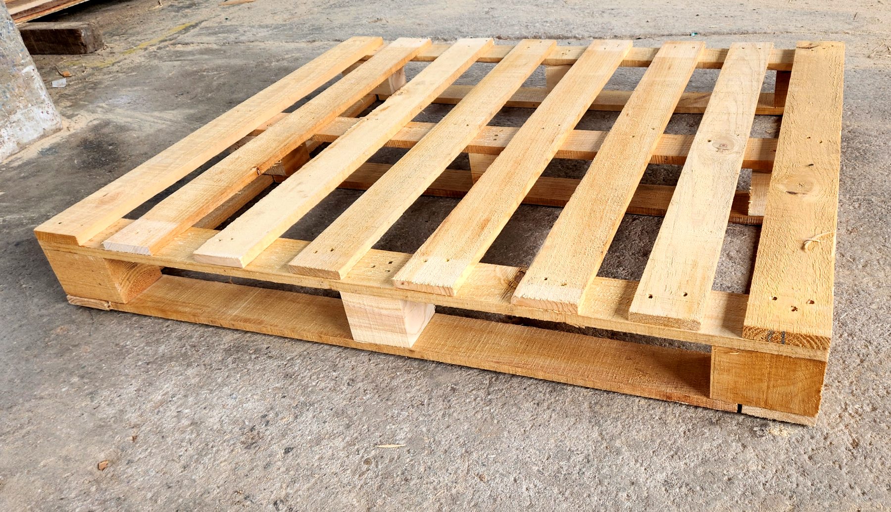 Tarima de madera nueva sobre piso de concreto